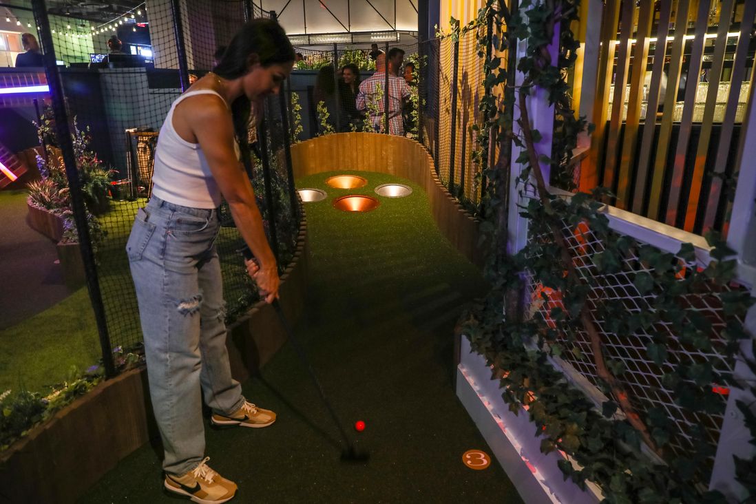 A miniature golf course, players and food